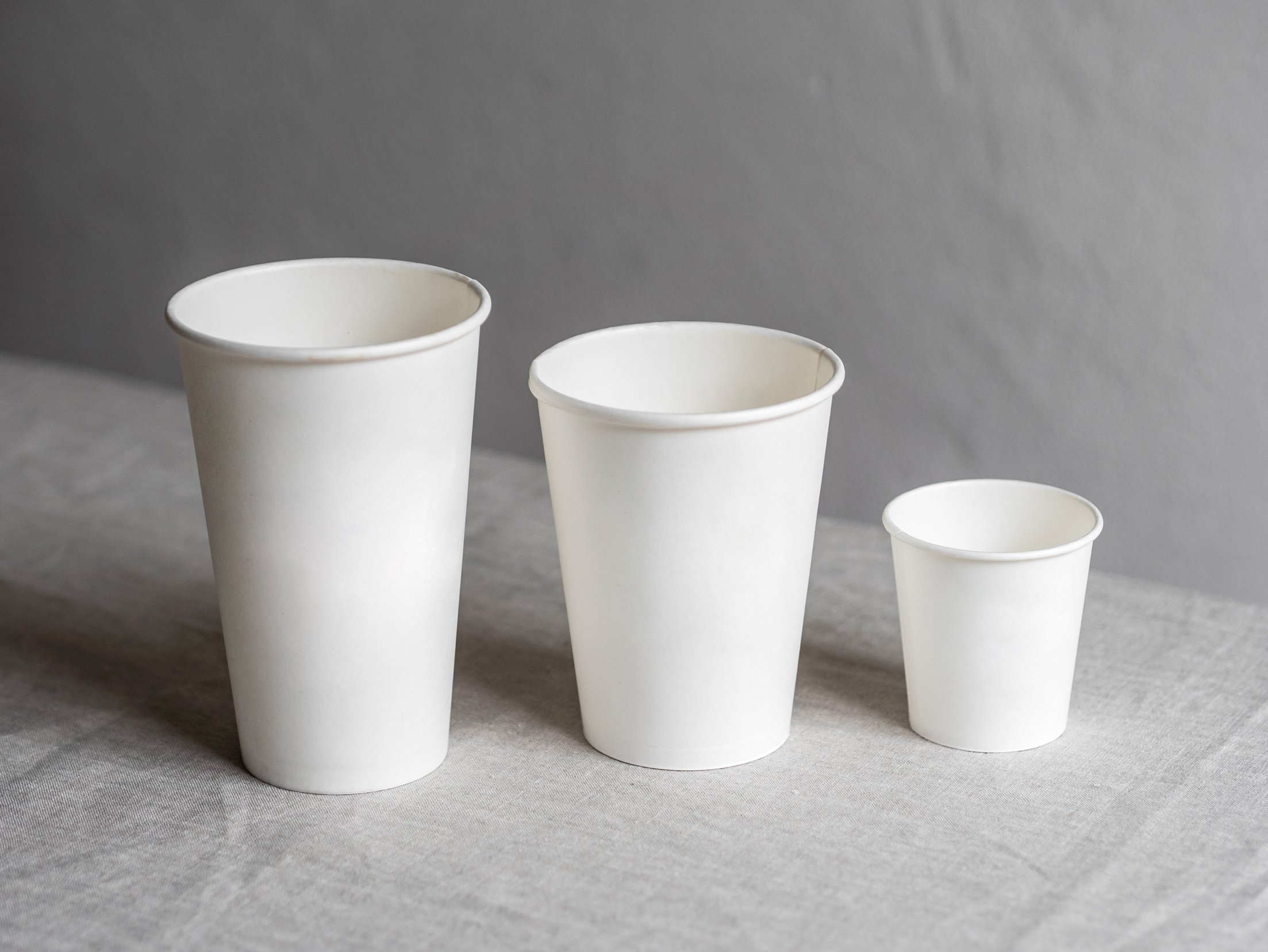 Three White Disposable Cups on White Table